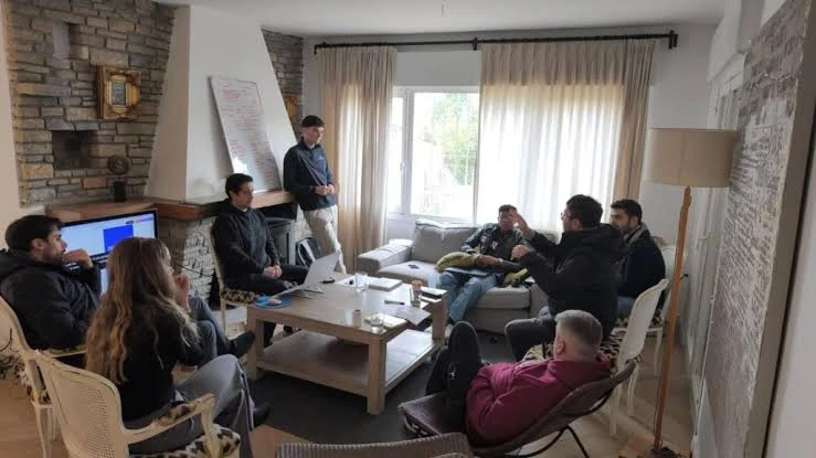 The TuManag3r team gathered in a living room, sharing ideas around a table