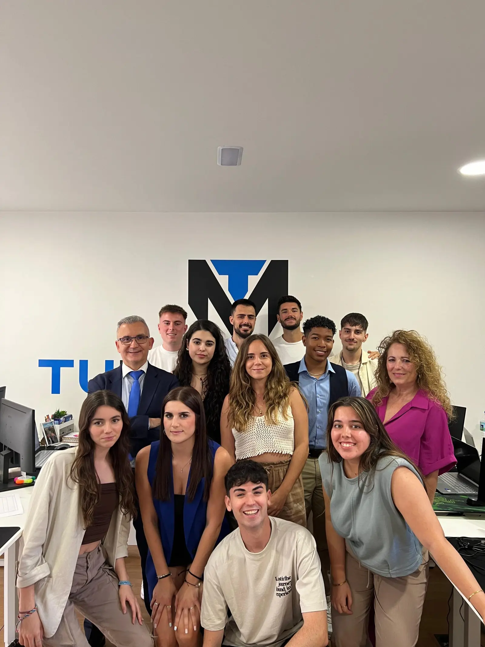 Group photo of the team under the logo