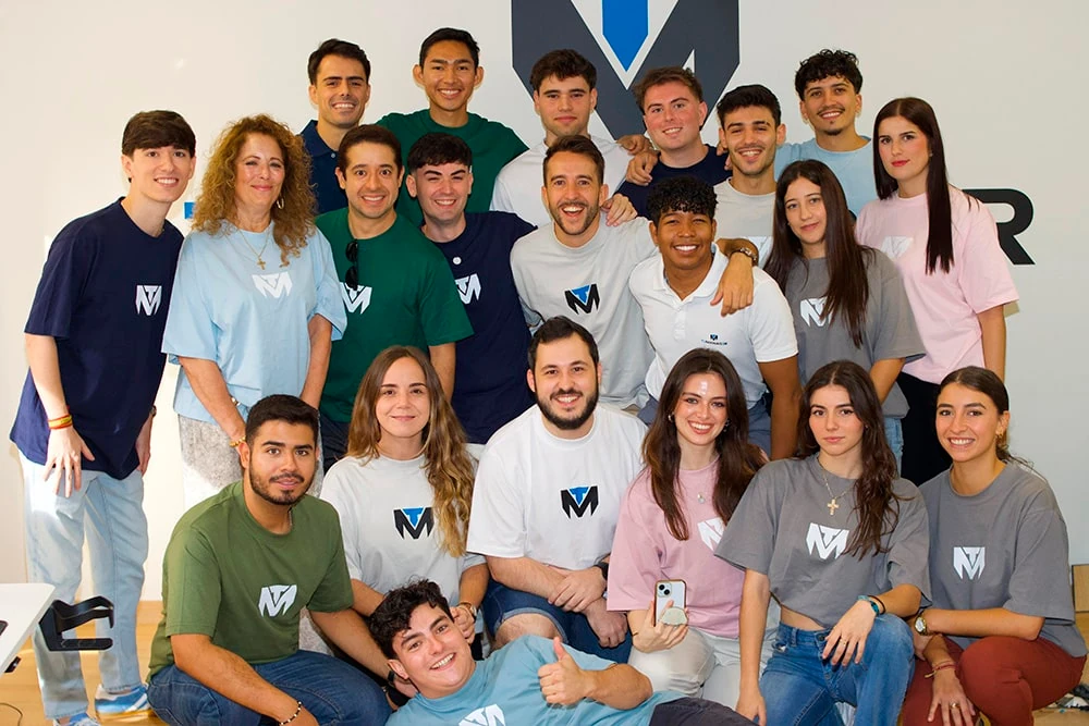 The TuManag3r team wearing agency T-shirts, gathered in front of its logo