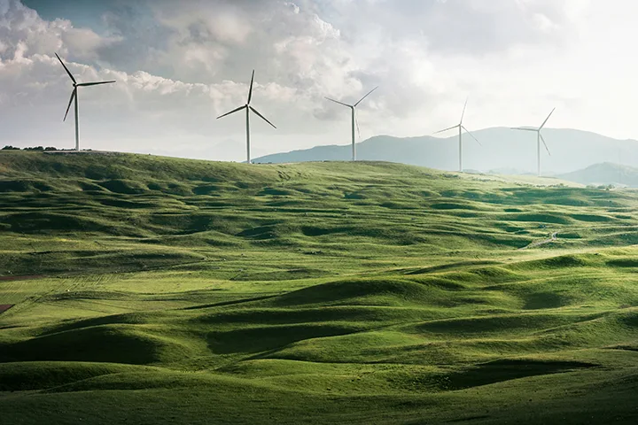 Wind turbines across green hills