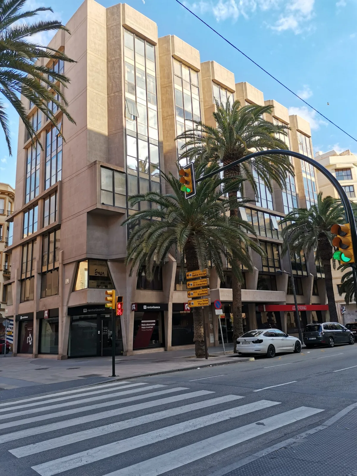 Edificio de oficinas en Málaga con palmeras y un paso de peatones