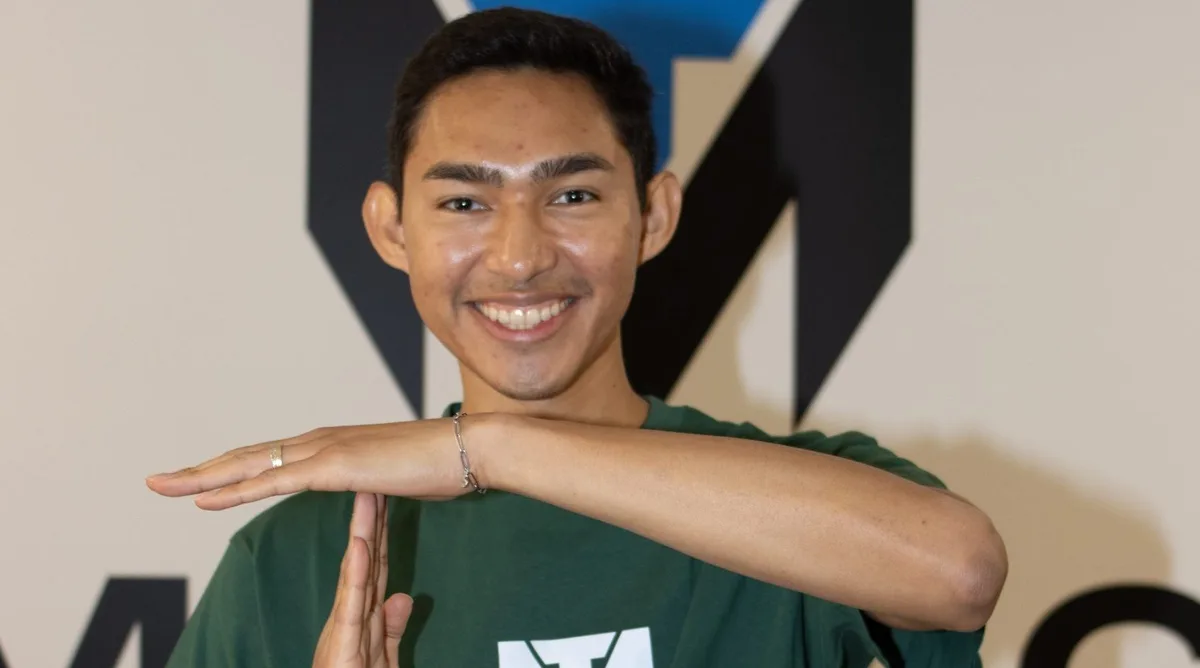 Fernanfloo smiling in front of the TuManag3r logo
