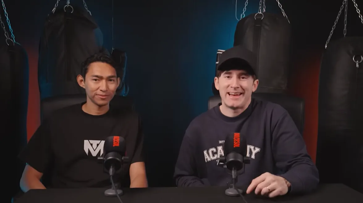 Two participants talking in front of microphones and punching bags